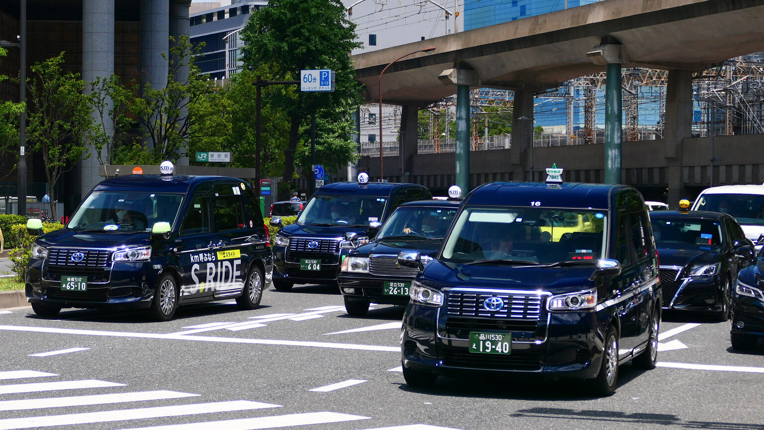 Dark blue taxis near the Marunouchi exit of Tokyo Station, one of them marked S.RIDE